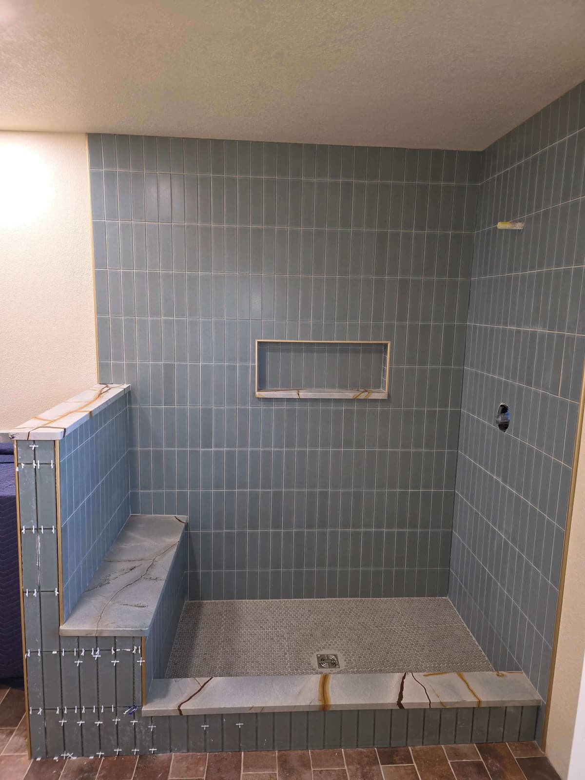 Custom tile shower installation with clean grout lines and niche